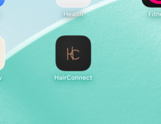 Het icoon van HairConnect op het beginscherm van een iPad: het HC-monogram in koper op charcoal.